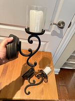 Front view of both wall sconces showing scroll arms, glass hurricanes and LED candles