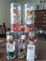 Group shot of five Bakerkins chef elf figurines in clear cylinders