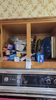 cabinet interior showing variety of bakeware and boxed wraps