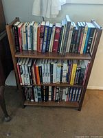 Full view of wooden bookshelf with books on two shelves