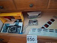 Drawer view showing Kodak Instamatic X-35 camera, flash cubes, Kodak box, Olympus camera, slides