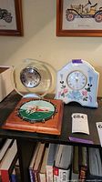 All three clocks on shelf: acrylic mantel, ceramic floral mantel, wooden golf wall clock