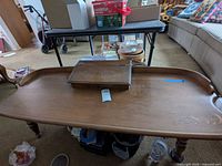 Full view of wooden coffee table showing tray-style edge and central storage box