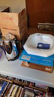 Overview of GE coffee percolator beside Corning Ware casserole on boxes