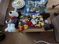Table with Snoopy plush, ornaments, pottery bell and Santa