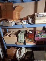 Shelves containing boxes, wooden boxes, floral box, X-Acto set, paint set, fabric