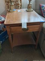 Full view of Brandt wooden end table showing top, drawer, legs and lower shelf