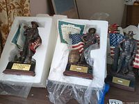 Three John Wayne Bradford Exchange sculptures in foam packing