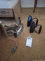 Electric Westinghouse iron with braided cord and two cast iron irons on carpet