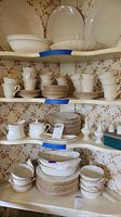 Shelved Lenox ivory china including cups, saucers, plates, sugar bowl, creamer and shakers