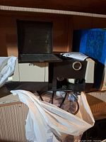 Projector left side with top cover open showing film path and power cord