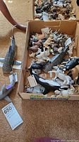 box containing numerous Schleich animal figurines including whale shark, orca, zebras, tiger, etc.