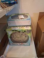 Two clock boxes stacked showing product name and artwork