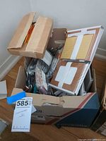 Open box showing notepad sets, pens, pencils