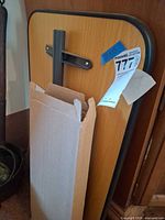 Full tabletop showing woodgrain surface, edge trim, tilt bracket and lot tag