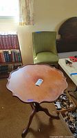 Pie crust pedestal table front view with chair behind