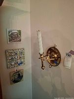 wall view showing three tiles and brass sconce