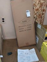 SSB cardboard carton standing upright on floor with instruction sheet visible