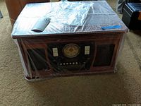 Front view of Victrola entertainment center wrapped in plastic