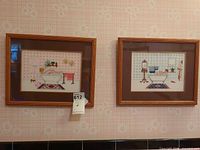 Two framed cross-stitch pictures on wall