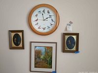 Group shot of wall clock and three framed artworks displayed on wall