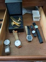 Drawer with five wristwatches, Timex plane clock in box, two small watch boxes