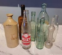 Group view of all eight bottles including stoneware and glass