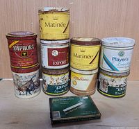 Group shot of all eleven tins stacked to show brand labels and relative condition
