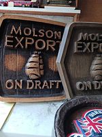 Two Molson Export On Draft carved wood signs side by side