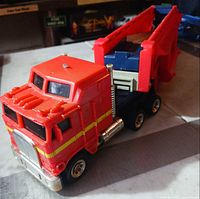front three-quarter view of red cab and attached red trailer