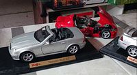 Mercedes-Benz SLK and Ferrari convertible on display bases