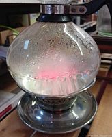 Glass kettle on heating base with water boiling