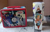 Front view of lunch box, Flake tin and pencil tin