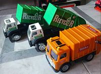 Three Tonka recycling trucks front angle
