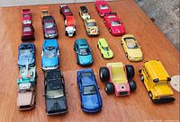 All 20 vehicles lined in four rows on wooden surface