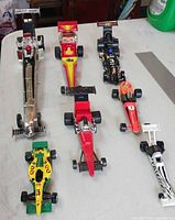 Seven dragsters lined up on table