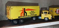 Side view of conventional cab truck showing logo and trailer details