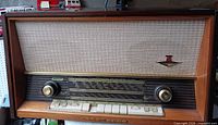 Front view showing woven speaker cloth, frequency scale, control knobs, pushbuttons, brand emblem