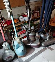 Four vintage floor-care machines lined up
