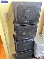 Stack of four black speakers showing Sony and Pioneer branding