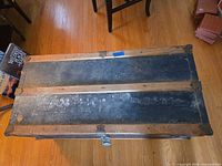 Top view of closed trunk showing wood slats, dark painted panels and metal corner reinforcements