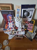 Overall lot showing books, magazines, teapot, cups, saucers, textiles