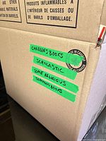 Exterior of box with tape labels noting children’s, Scholastic, religious, teaching books