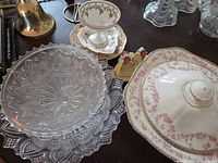 Overall view showing pressed glass compote, pressed glass plate stack, porcelain covered bowl and other china