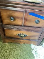 Front view showing three drawers and brass-tone hardware