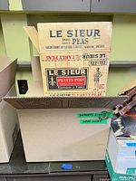 Box exterior marked Le Sieur Peas and open box below showing Reader's Digest tape label