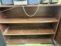 Front view of entire bookcase showing three shelves and cable hole