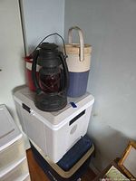 Stack of coolers, lantern, and jugs showing relative sizes and colours