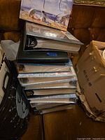 Stack of nine assorted hardcover photo albums on sofa