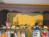 Shelf view showing straw goose, multiple ceramic fruit plaques and flying duck plaques